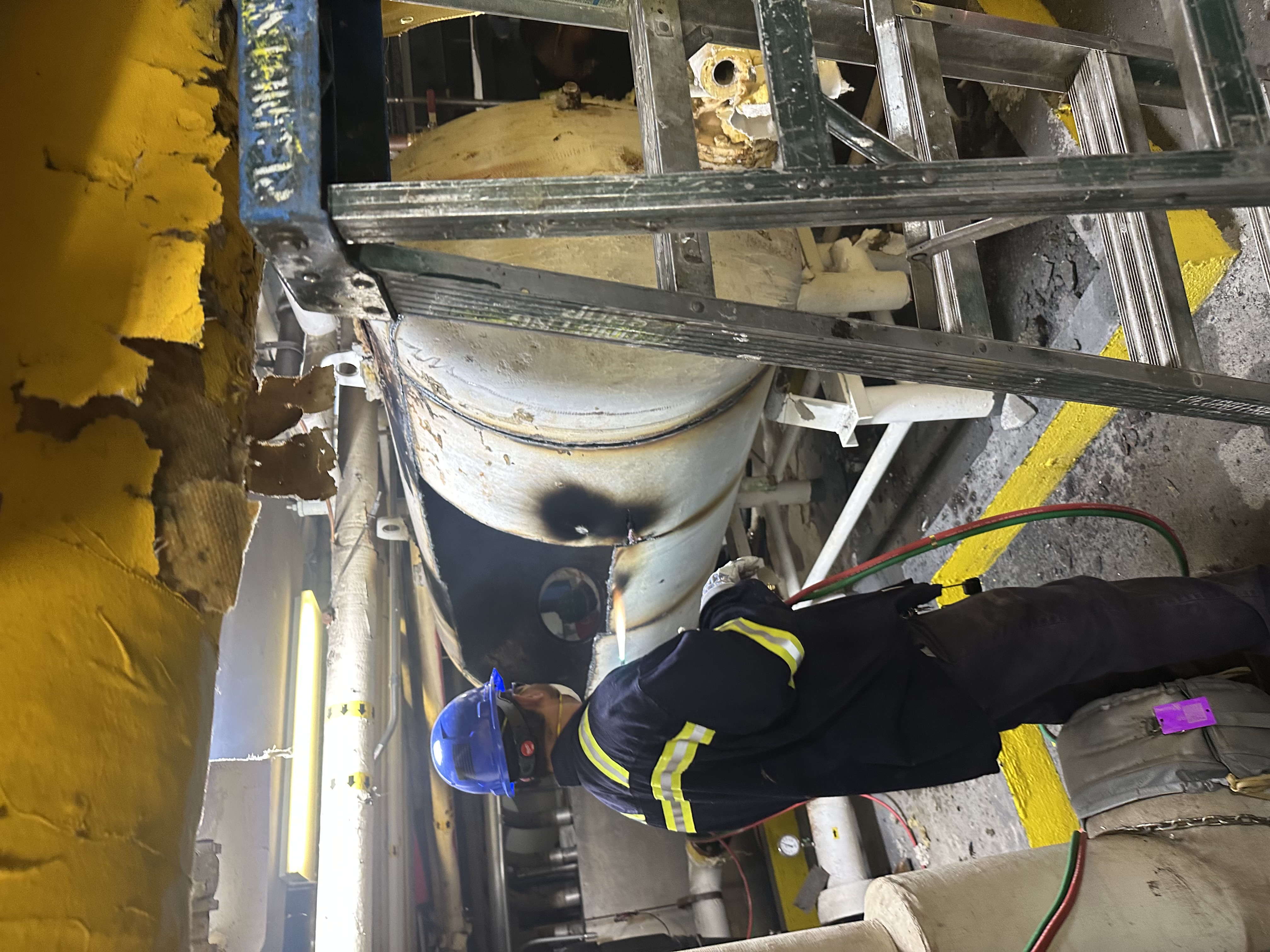 Worker servicing industrial vessel
